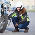 A woman checks on her motorcycle tire