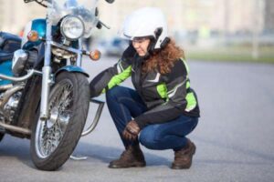 A woman checks on her motorcycle tire